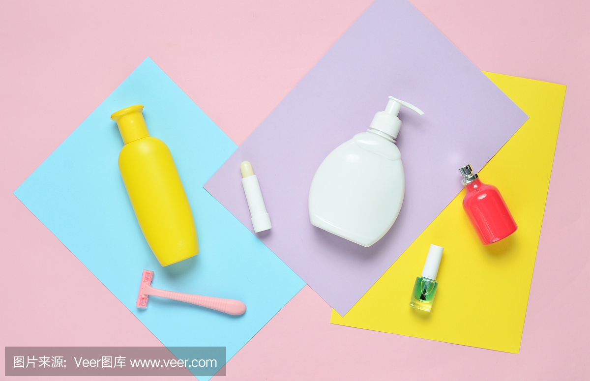产品为女性美容护理用彩纸作背景。一瓶洗发精,肥皂,剃毛刀,香水瓶,口红,指甲油。俯视图